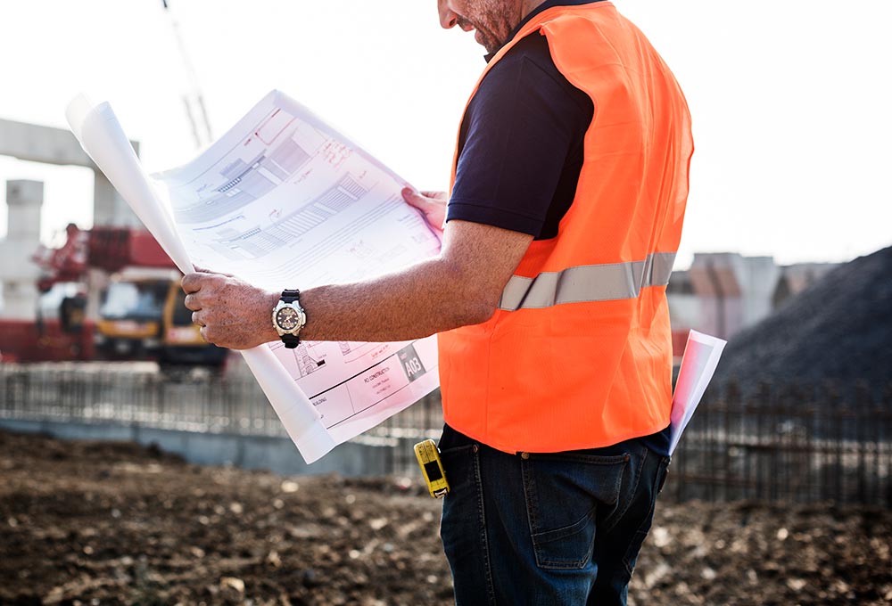 Builder looking at plans on building site